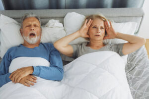 Man with sleep apnea, partner covering her ears
